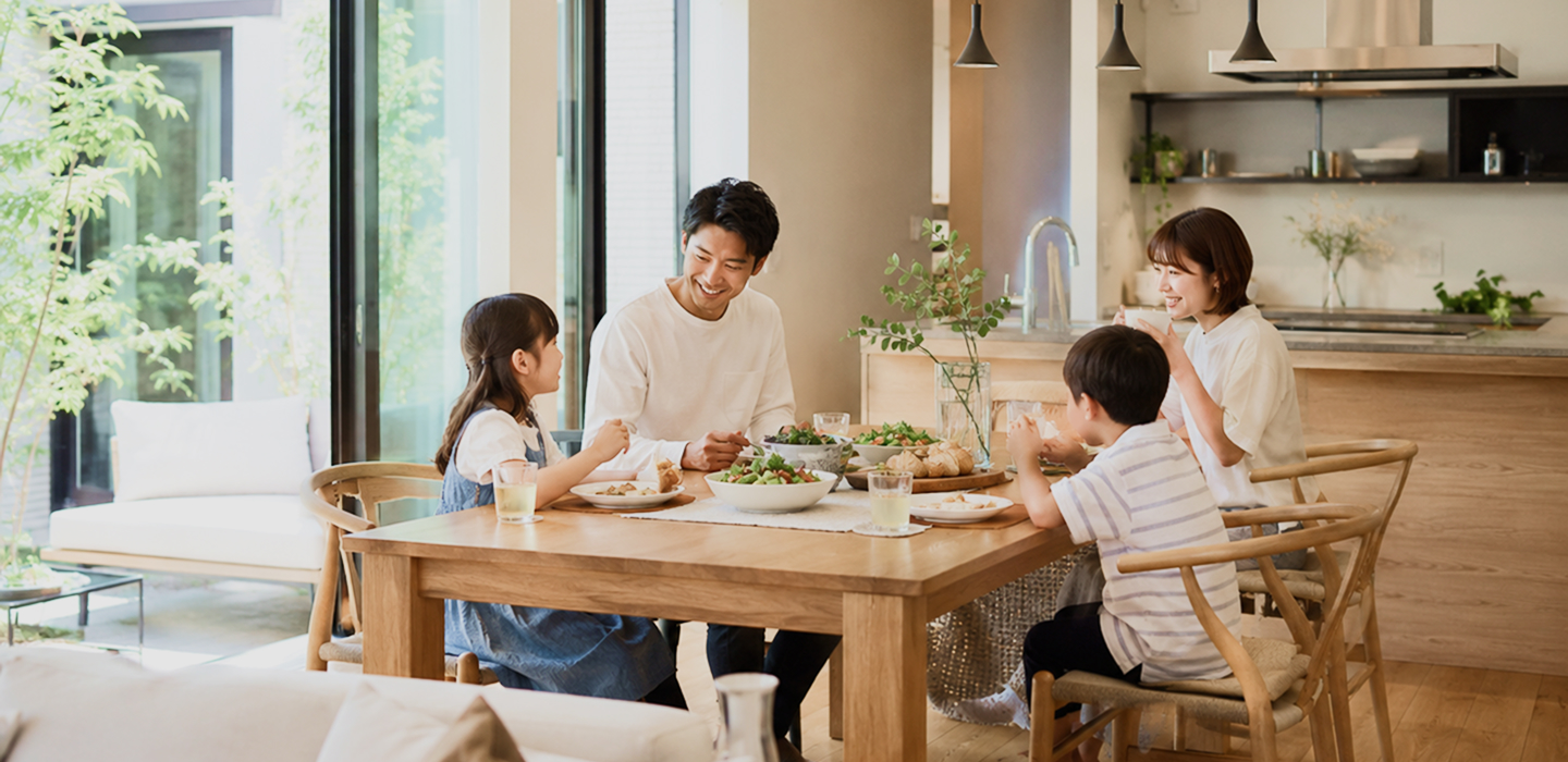明るい住まいの食卓で団らんする家族